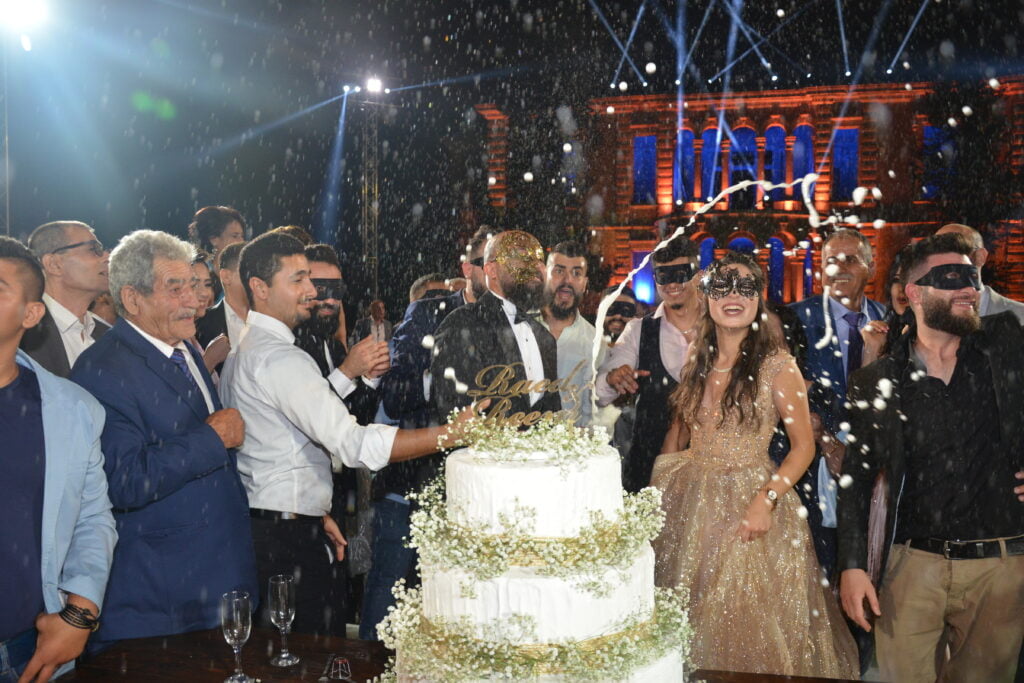 Bride and groom with friends cutting cake