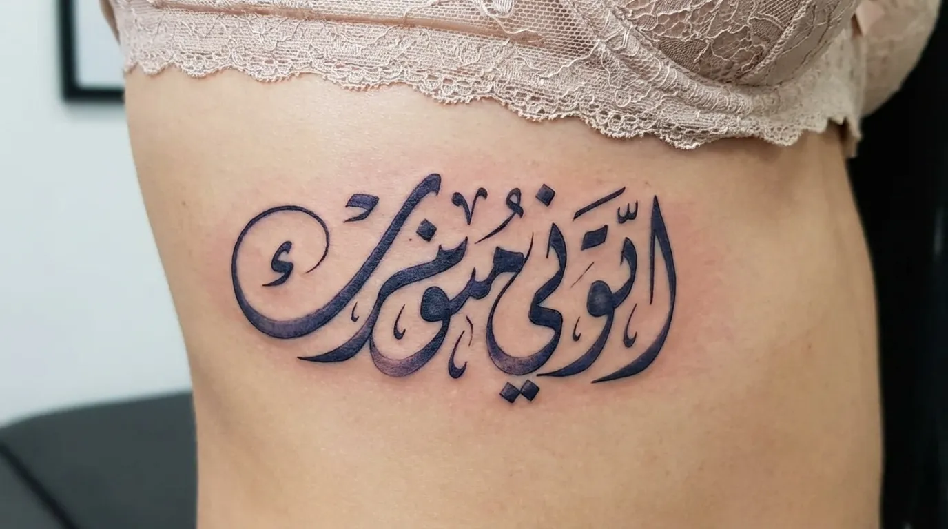 وشم بخط الديواني الانسيابي على الضلوع بتداخلات فنية