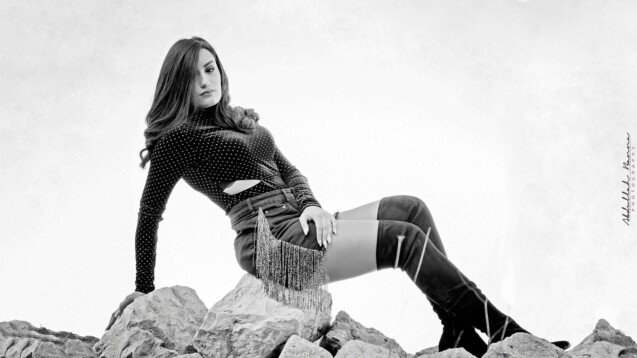 Dramatic black-and-white portrait of a woman lying on rocks