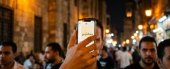 صورة مقربة لهاتف محمول يعرض رسالة نصية بكلمة وحشتني مع خلفية ليلية في القاهرة